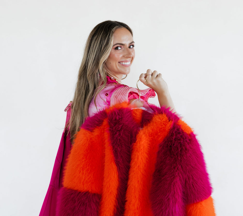 Haley J. wearing her Pink Party Top while holding her pink and orange fur coat on a white background.